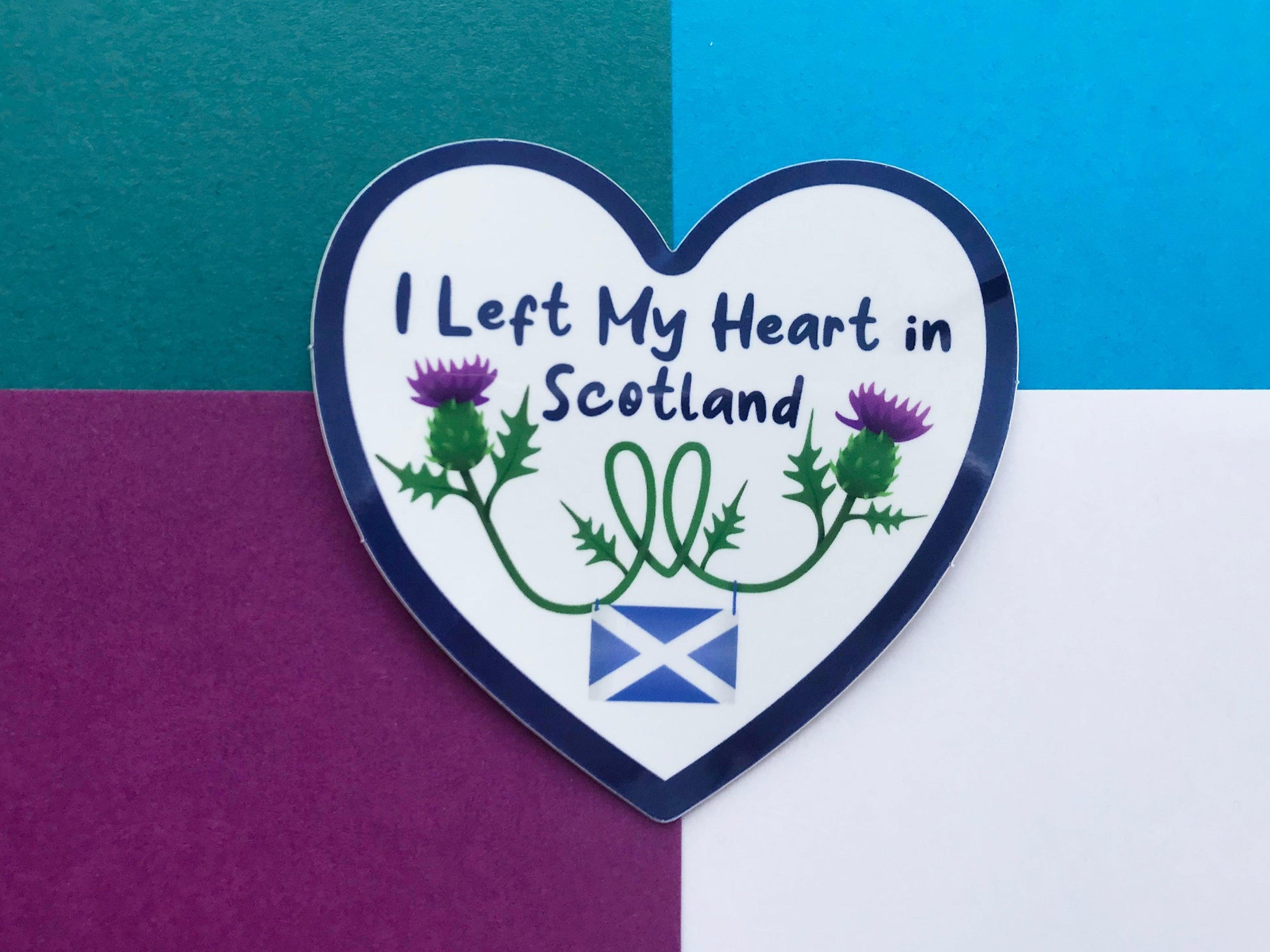 A photo of a heart shaped sticker with the words "I left my heart in Scotland" on it with thistles and a saltire flag